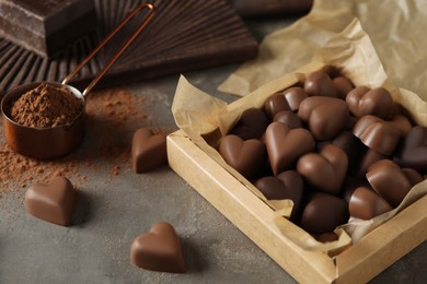 Photo of Beautiful heart shaped chocolate candies on black table