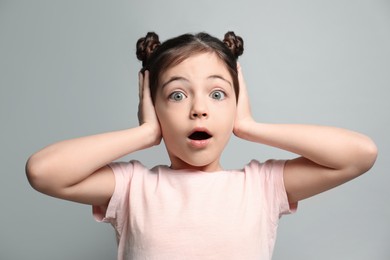 Photo of Little girl feeling fear on grey background