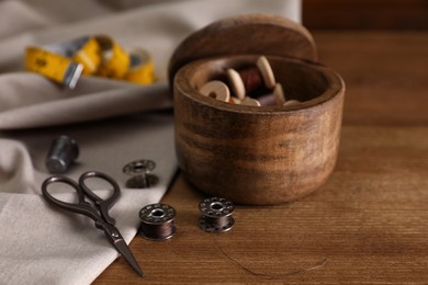 Set of sewing supplies and accessories on wooden table