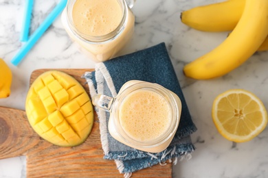 Mason jars with healthy detox smoothie and ingredients on table, top view