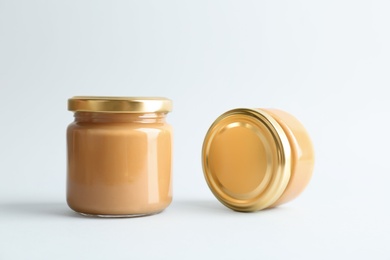 Photo of Jars of peanut butter on white background