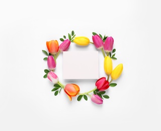 Photo of Beautiful composition with spring flowers and blank card on white background, top view. Space for text