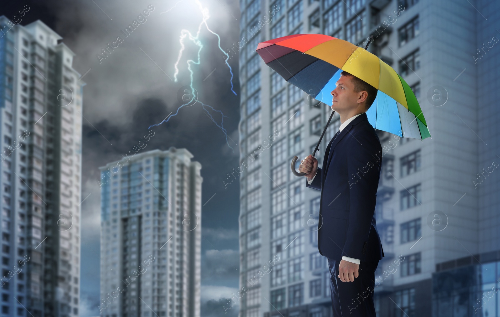 Image of Businessman with umbrella in city center. Insurance concept