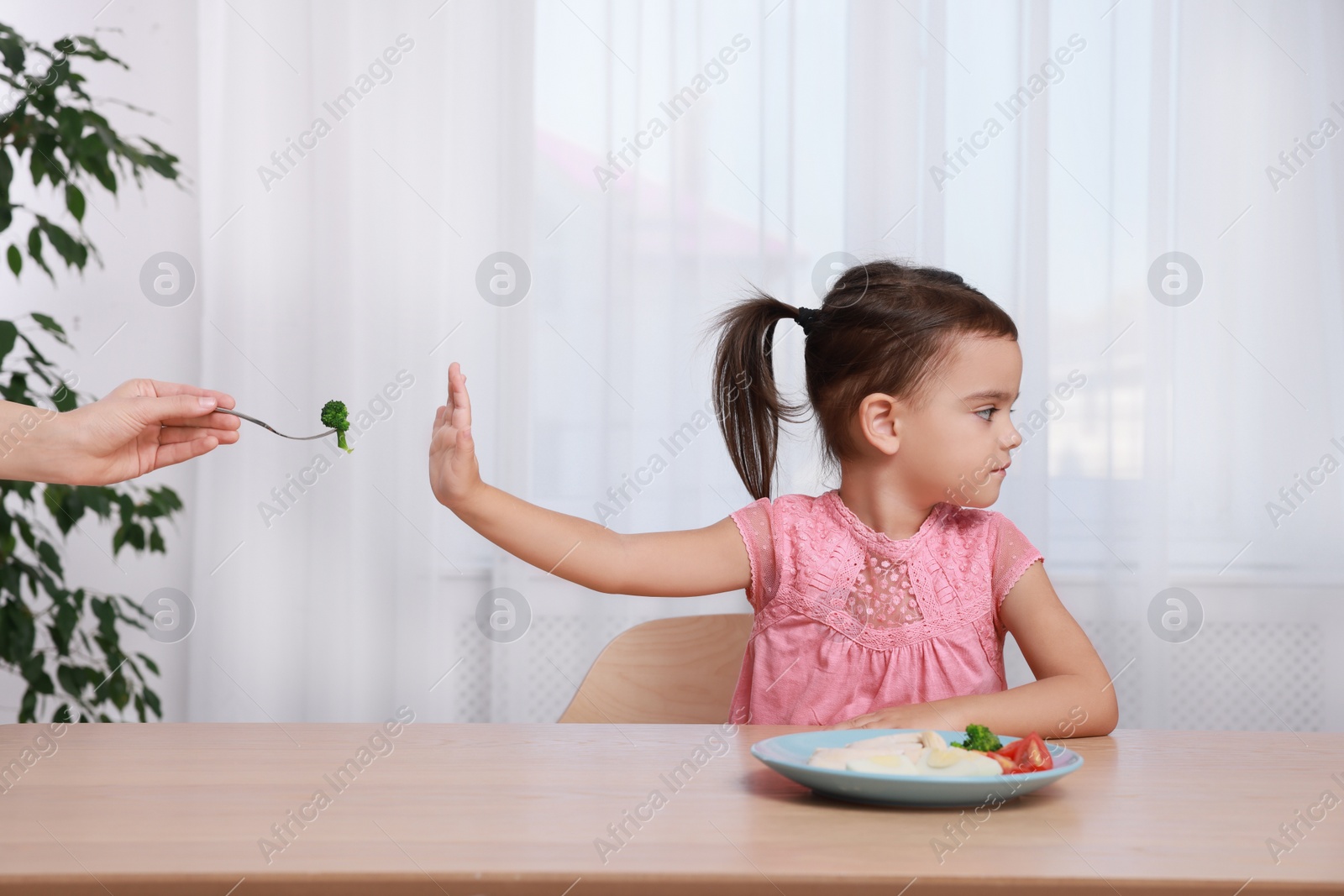 Photo of Cute little girl refusing to eat her breakfast at home