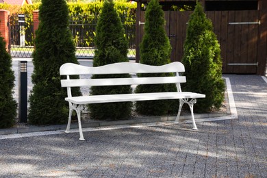 Photo of Stylish white wooden bench in garden on sunny day