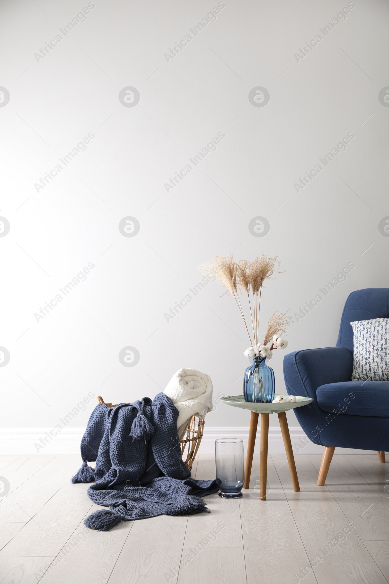 Photo of Basket with soft plaids in living room interior