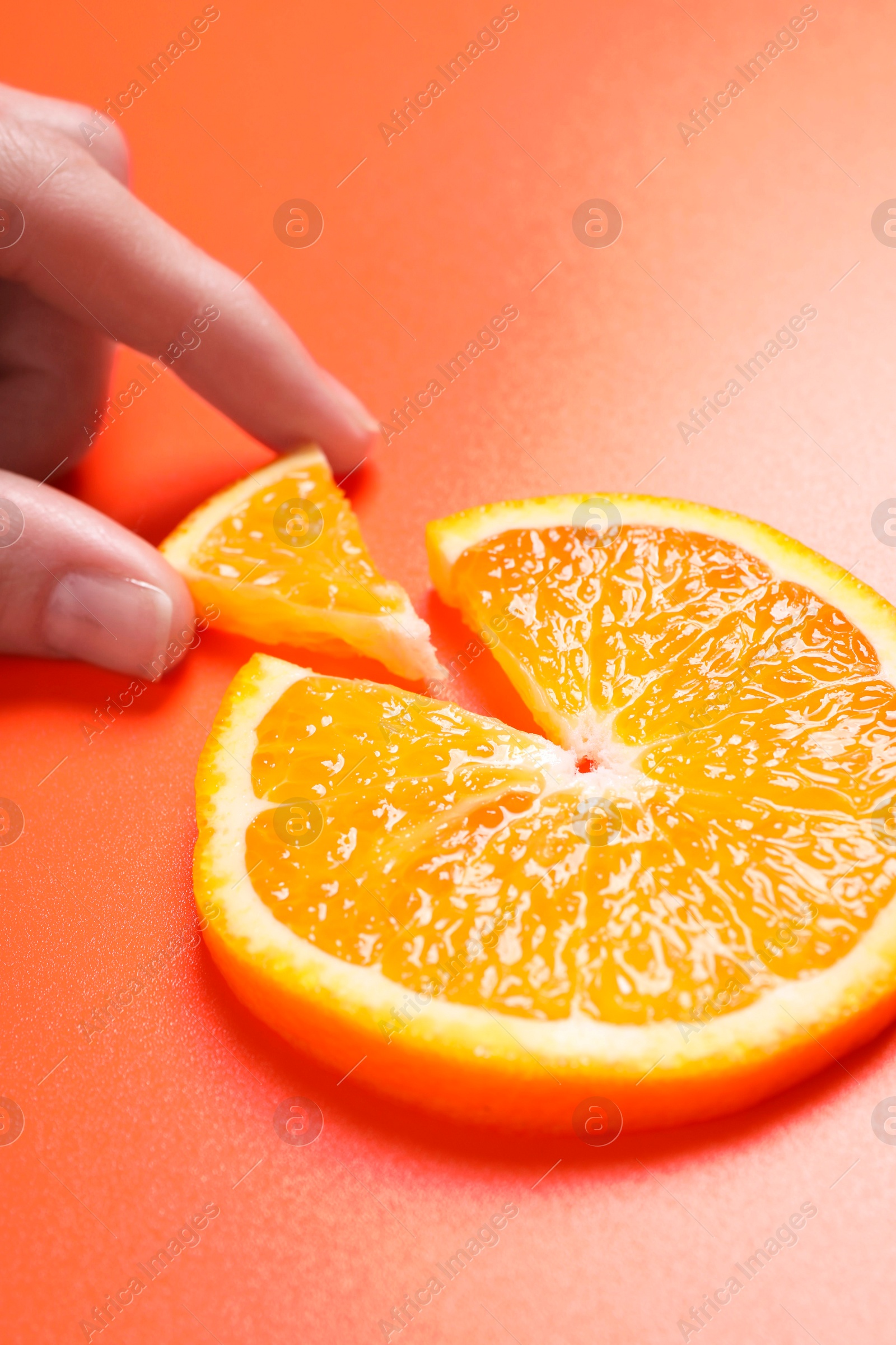 Photo of Woman with slices of juicy orange on terracotta background, closeup