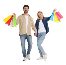 Photo of Family shopping. Happy couple with many colorful bags holding hands on white background