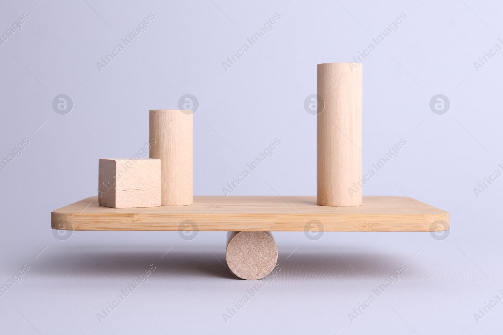 Photo of Equality concept. Seesaw scale with wooden blocks on light background