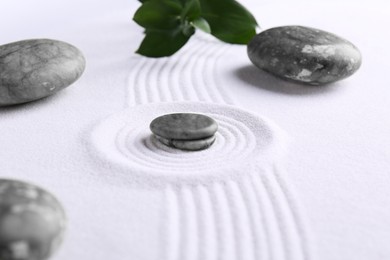 Photo of Zen concept. Stones, leaves and pattern on white sand, closeup