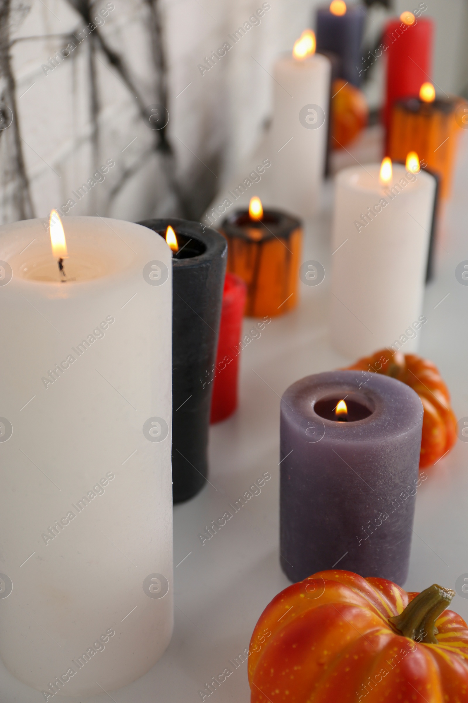 Photo of Burning candles and different Halloween decor indoors