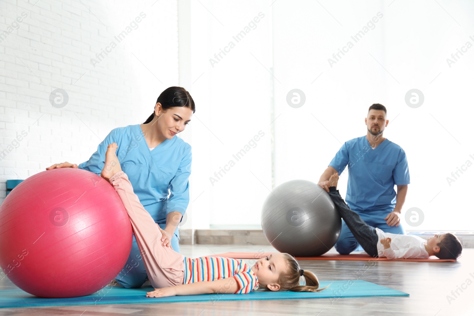 Photo of Orthopedists working with little children in hospital gym