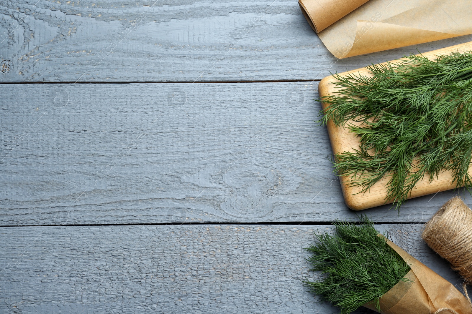 Photo of Fresh dill on grey wooden table, flat lay. Space for text