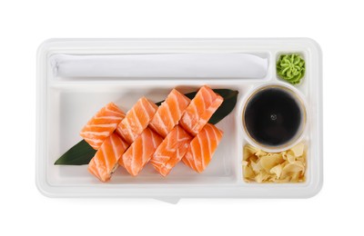 Photo of Food delivery. Delicious sushi rolls with soy sauce, ginger, wasabi and chopsticks in plastic container isolated on white, top view