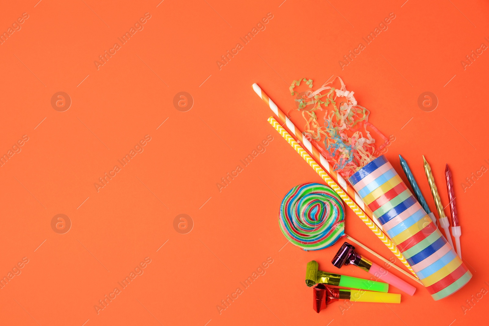 Photo of Party cracker and different festive items on orange background, flat lay. Space for text