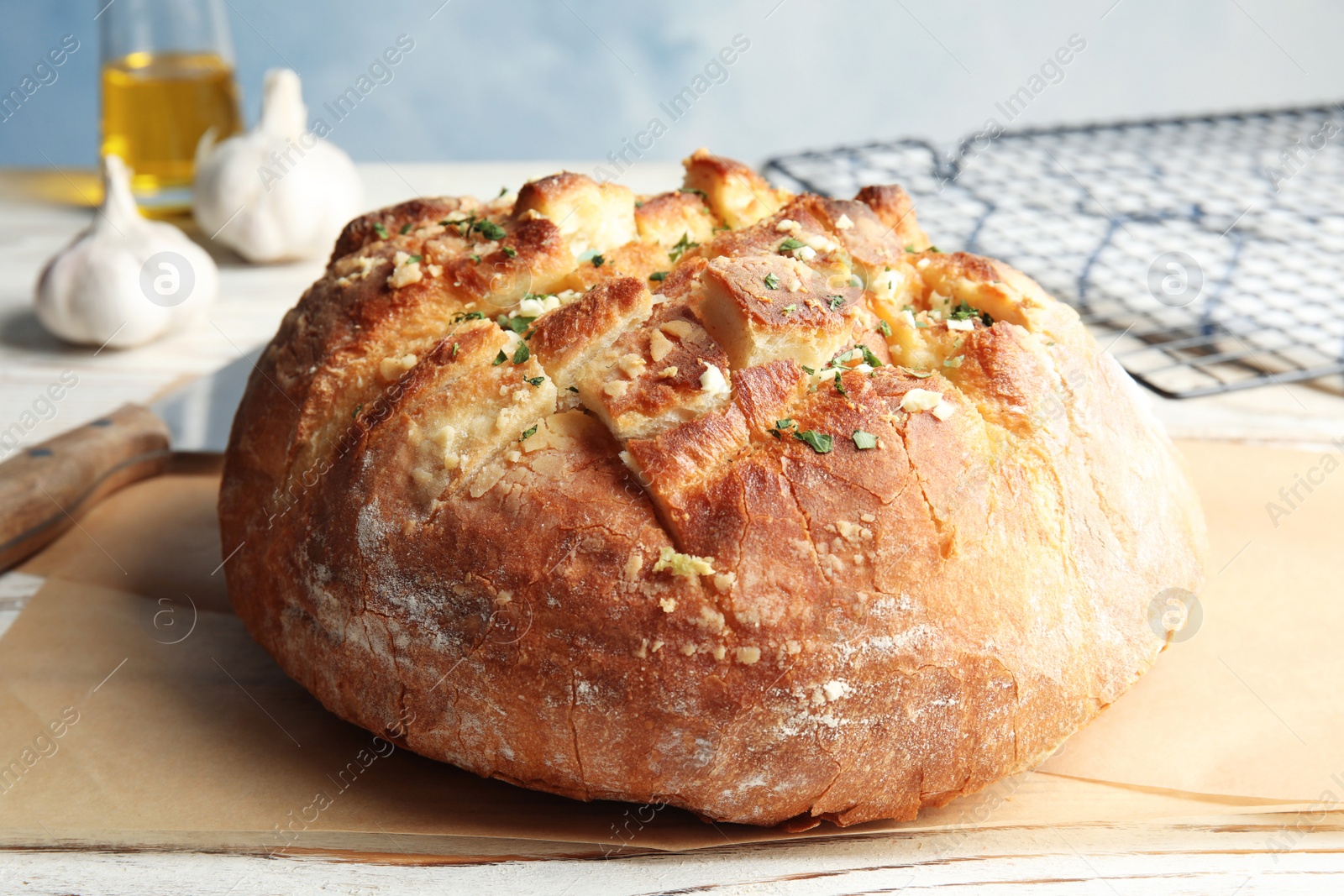 Photo of Delicious homemade garlic bread with herbs on table