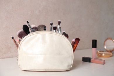 Bag with makeup brushes on dressing table