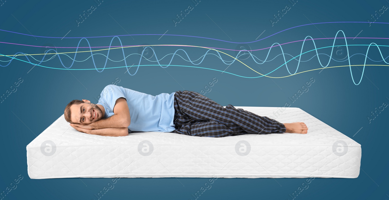 Image of Happy man lying on mattress against blue background. Healthy circadian rhythm and sleep habits