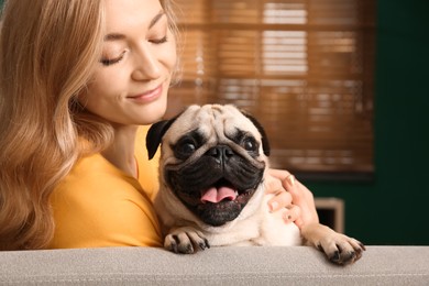 Photo of Woman with cute pug dog at home. Animal adoption