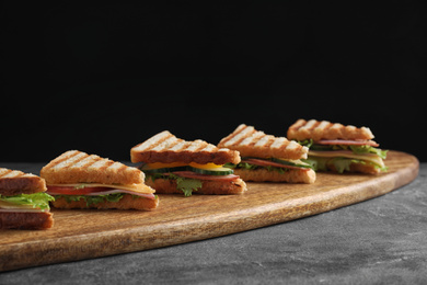 Photo of Tasty sandwiches with ham on grey table