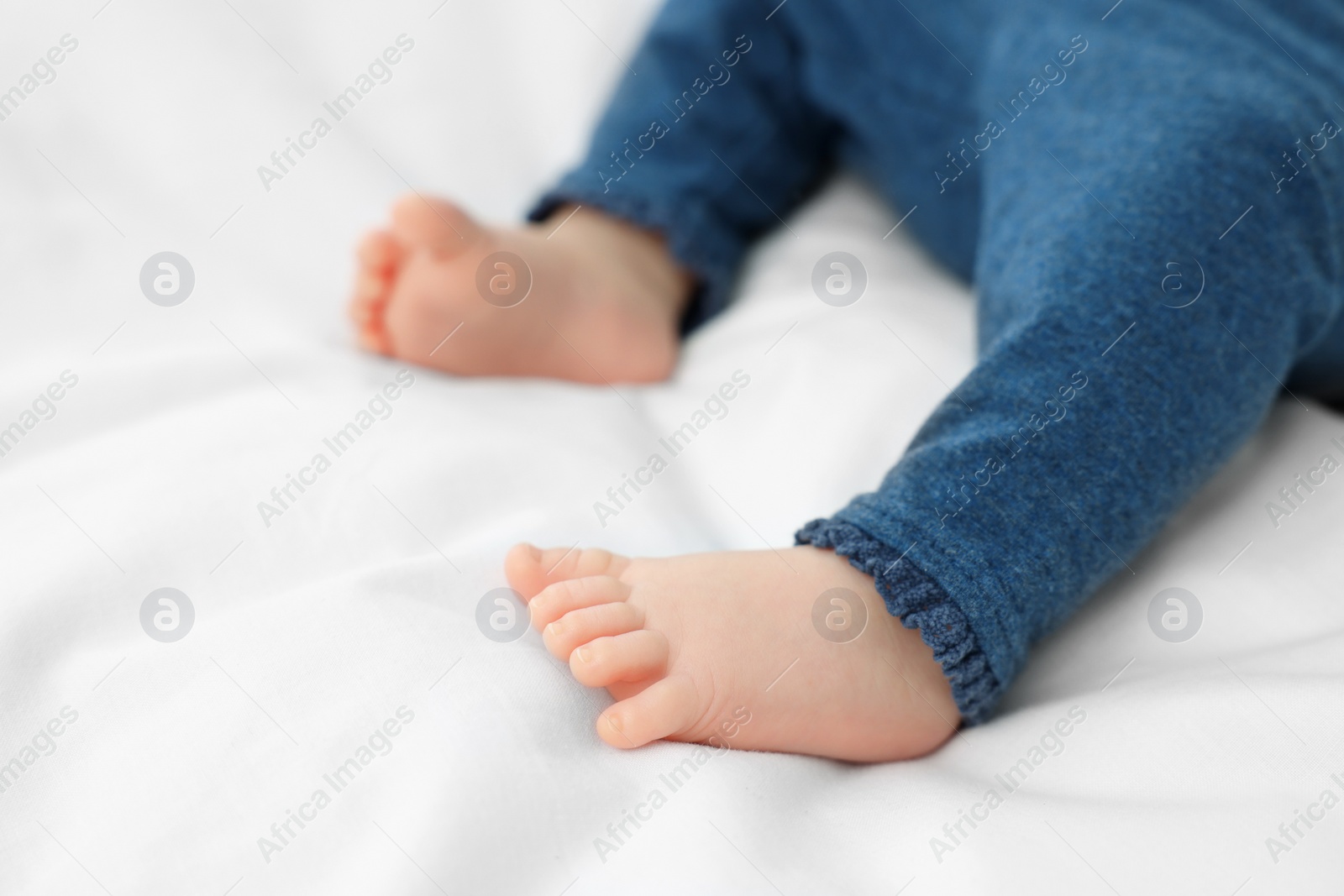 Photo of Newborn baby lying on white blanket, closeup