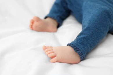 Photo of Newborn baby lying on white blanket, closeup