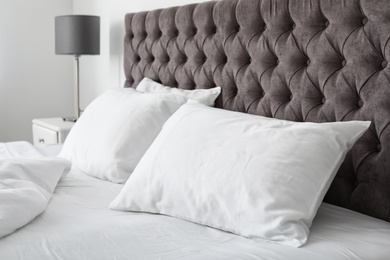 Photo of Soft white pillows on comfortable bed indoors