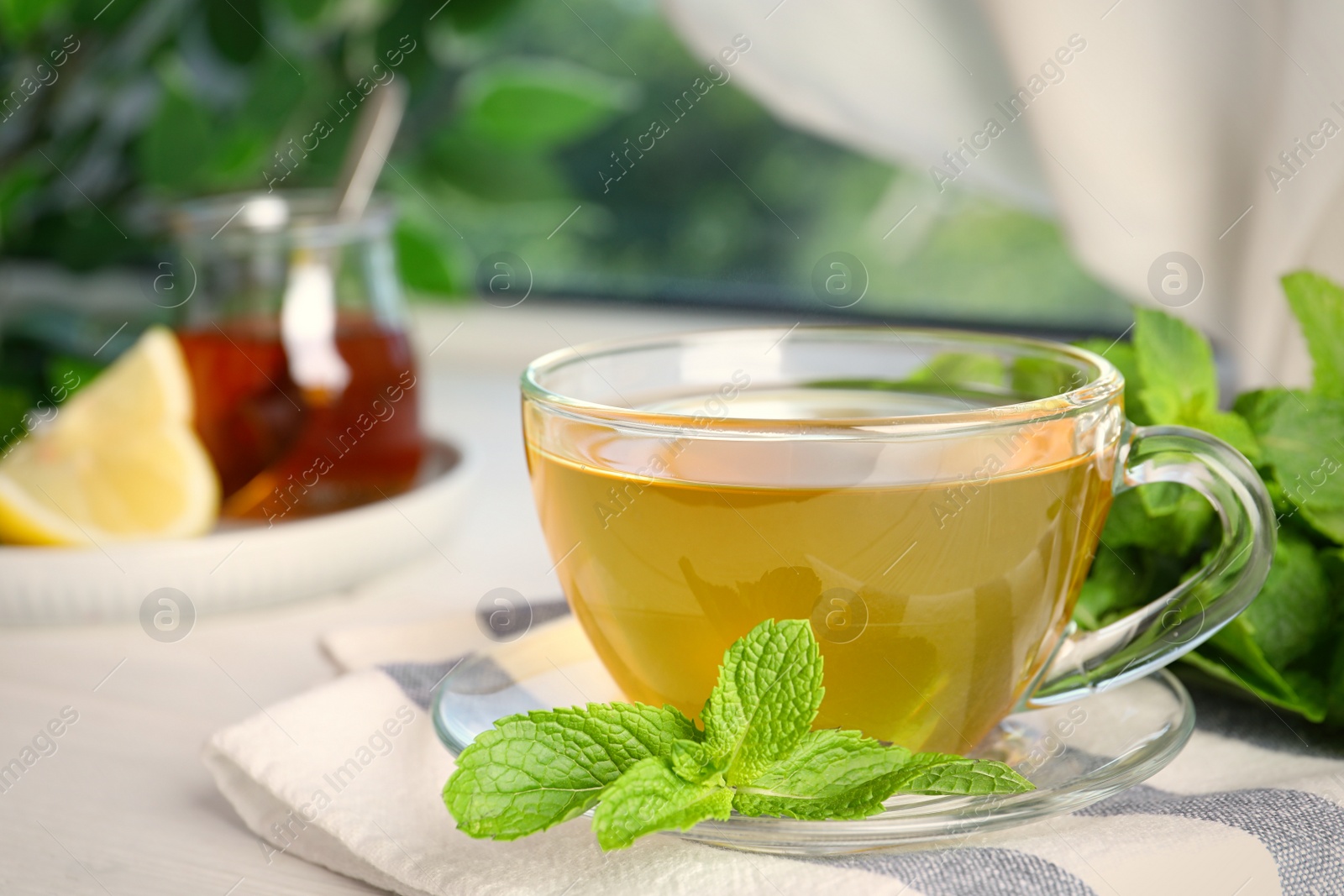 Photo of Fresh green tea with mint leaves on table