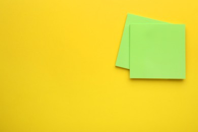 Photo of Paper notes on yellow background, top view. Space for text