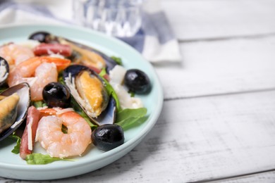 Photo of Platedelicious salad with seafood on white wooden table, closeup. Space for text