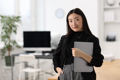 Photo of Portrait of beautiful businesswoman with laptop in office. Space for text