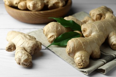 Photo of Fresh ginger with leaves on white wooden table