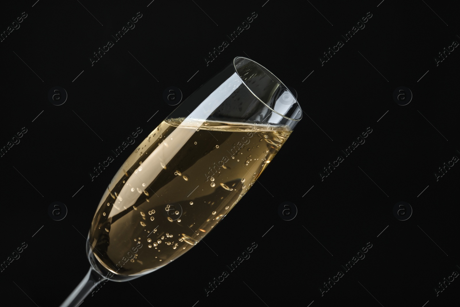 Photo of Glass of sparkling wine on black background