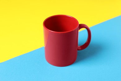 Photo of One red ceramic mug on color background