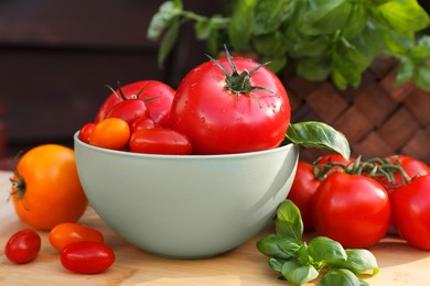Photo of Different sorts of tomatoes on wooden table