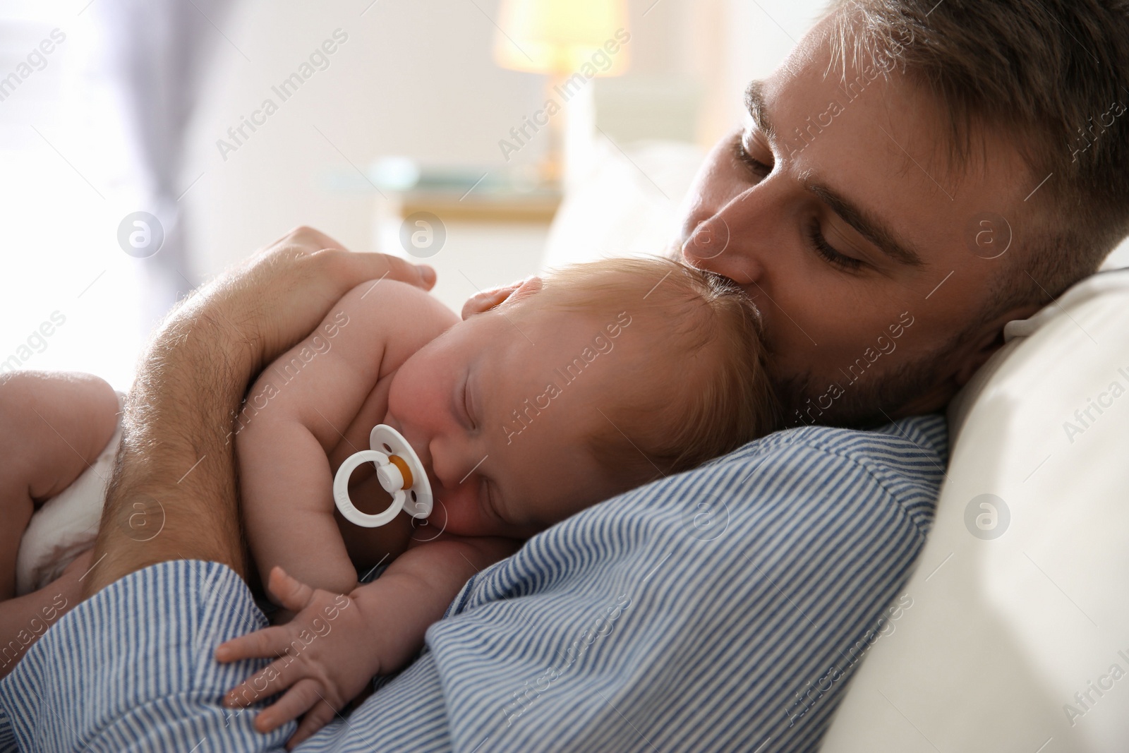 Photo of Father with his newborn son at home