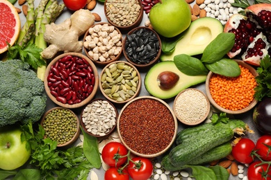 Photo of Different vegetables, seeds and fruits on grey table, flat lay. Healthy diet