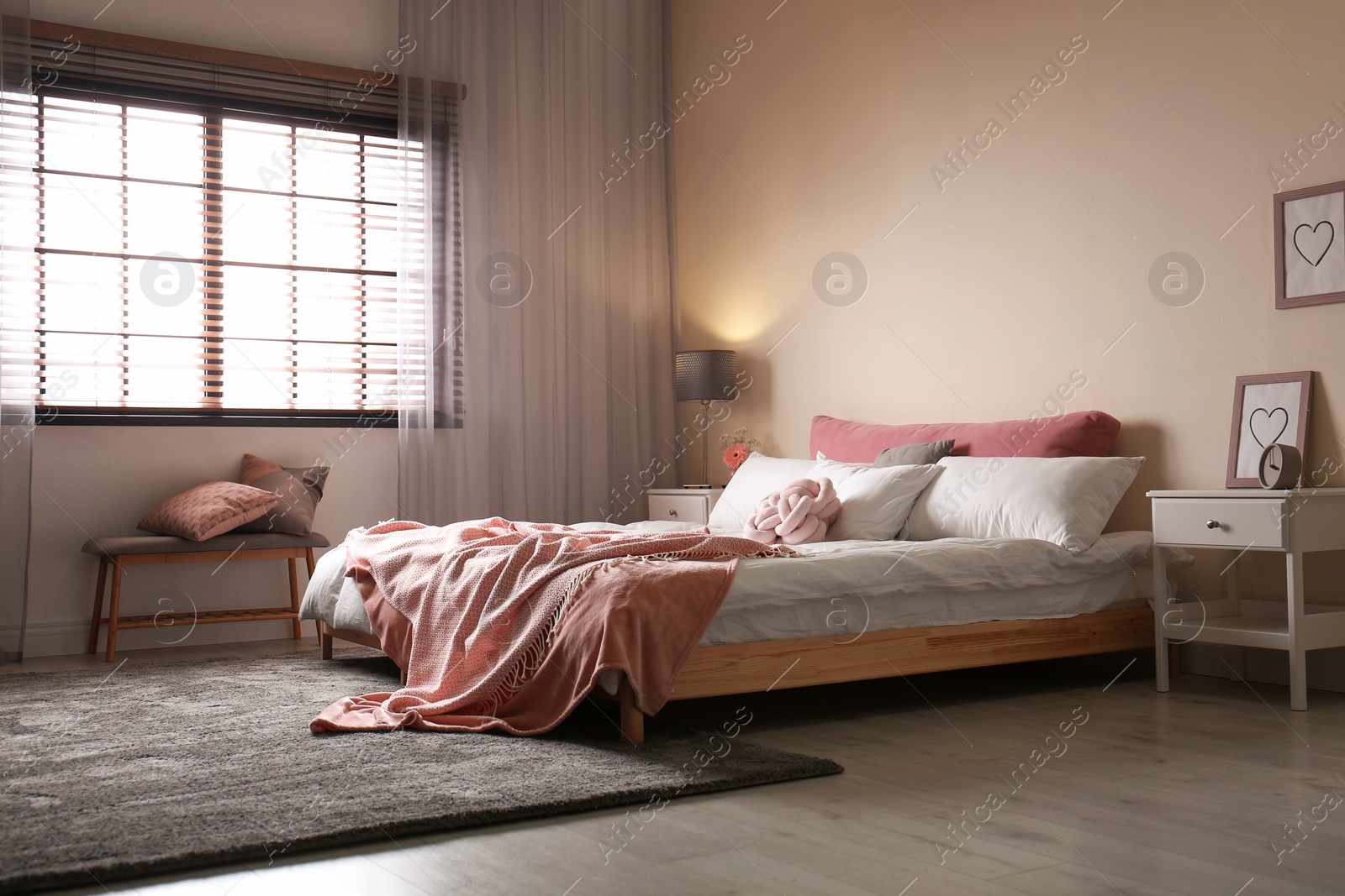 Photo of Modern room interior with comfortable double bed and window blinds