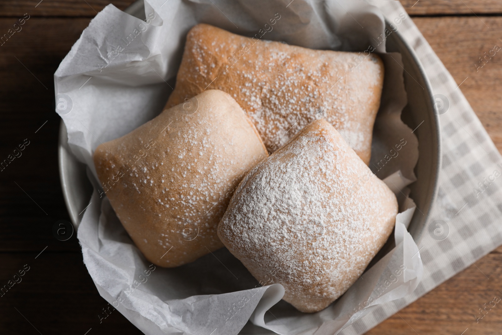 Photo of Fresh crispy ciabattas on wooden table, flat lay