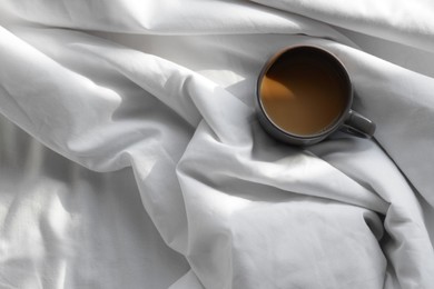 Photo of Aromatic morning coffee on bed, top view. Space for text