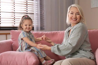 Photo of Happy granddaughter and grandmother together at home