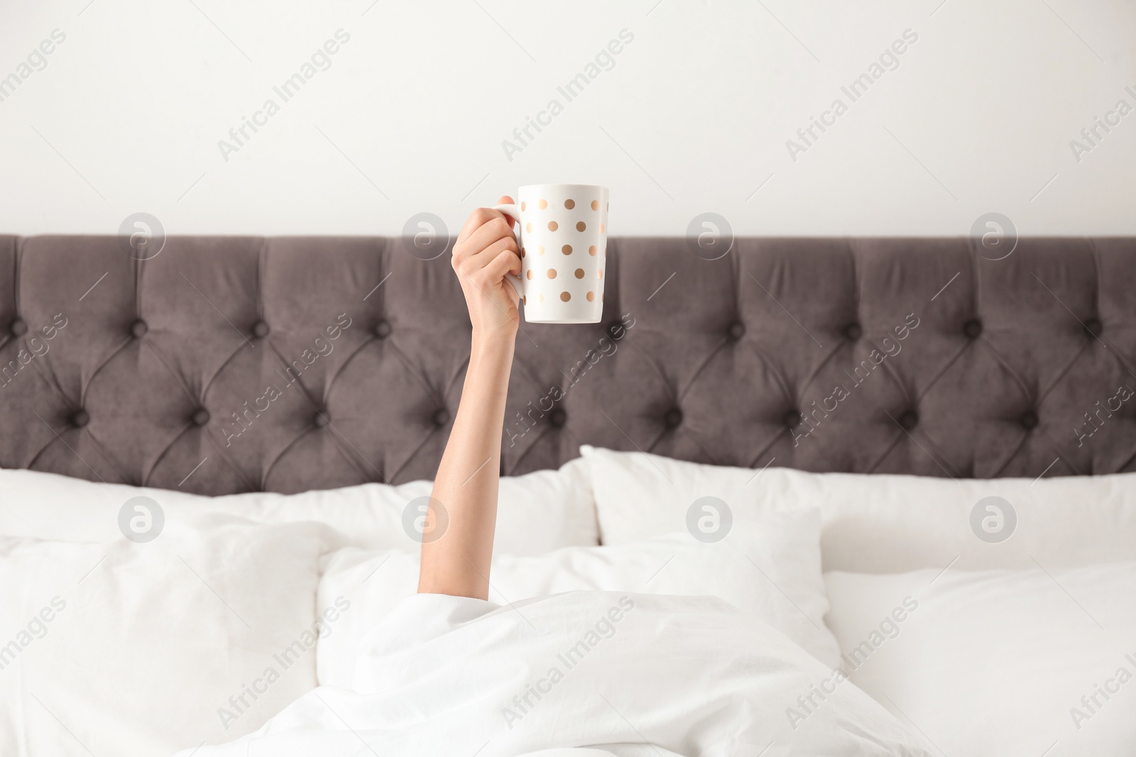 Photo of Woman with cup of coffee in bed, closeup. Lazy morning