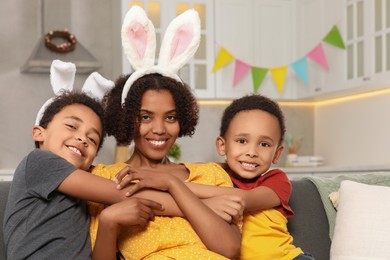 Happy African American mother and her cute children in kitchen