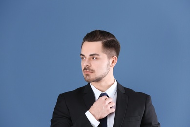 Portrait of young man with beautiful hair on blue background