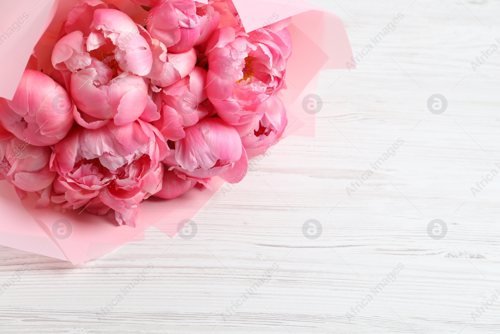 Photo of Bouquet of beautiful pink peonies on white wooden table. Space for text