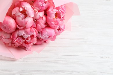 Bouquet of beautiful pink peonies on white wooden table. Space for text