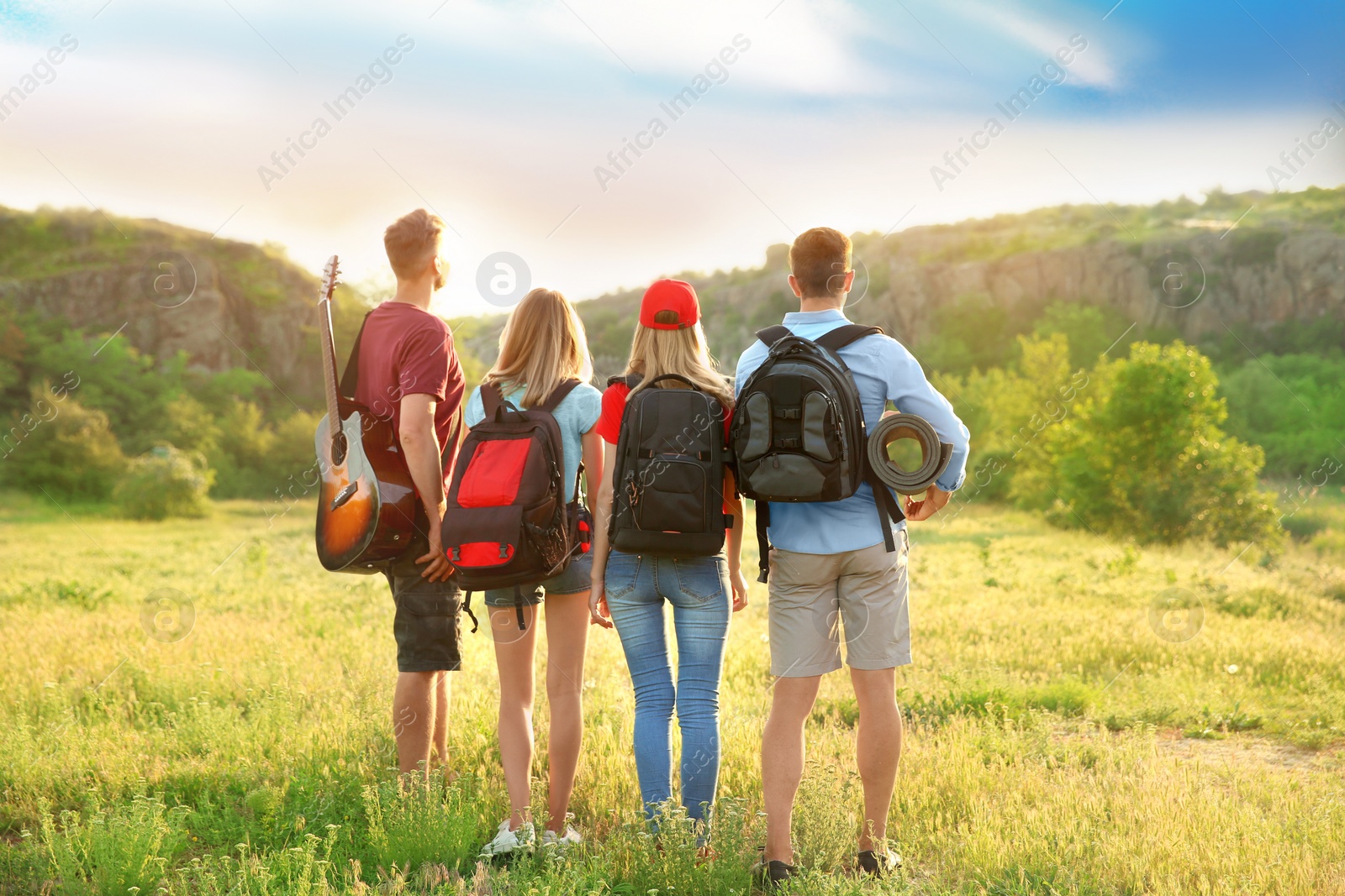 Photo of Group of young people with backpacks in wilderness. Camping season