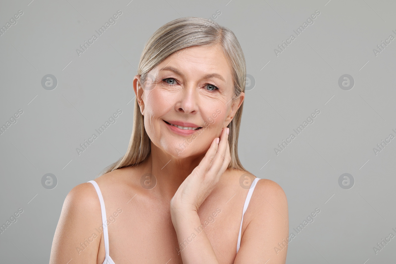 Photo of Beautiful mature woman with healthy skin on gray background