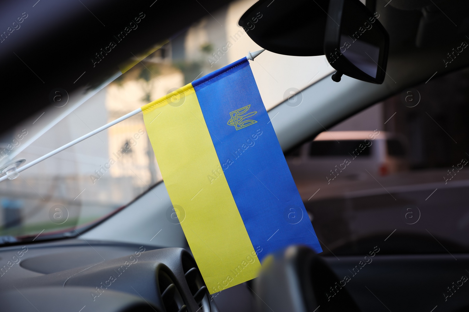 Photo of National flag of Ukraine on windshield inside car