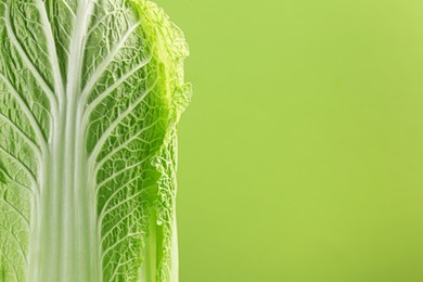 Photo of Fresh ripe Chinese cabbage on light green background, closeup. Space for text